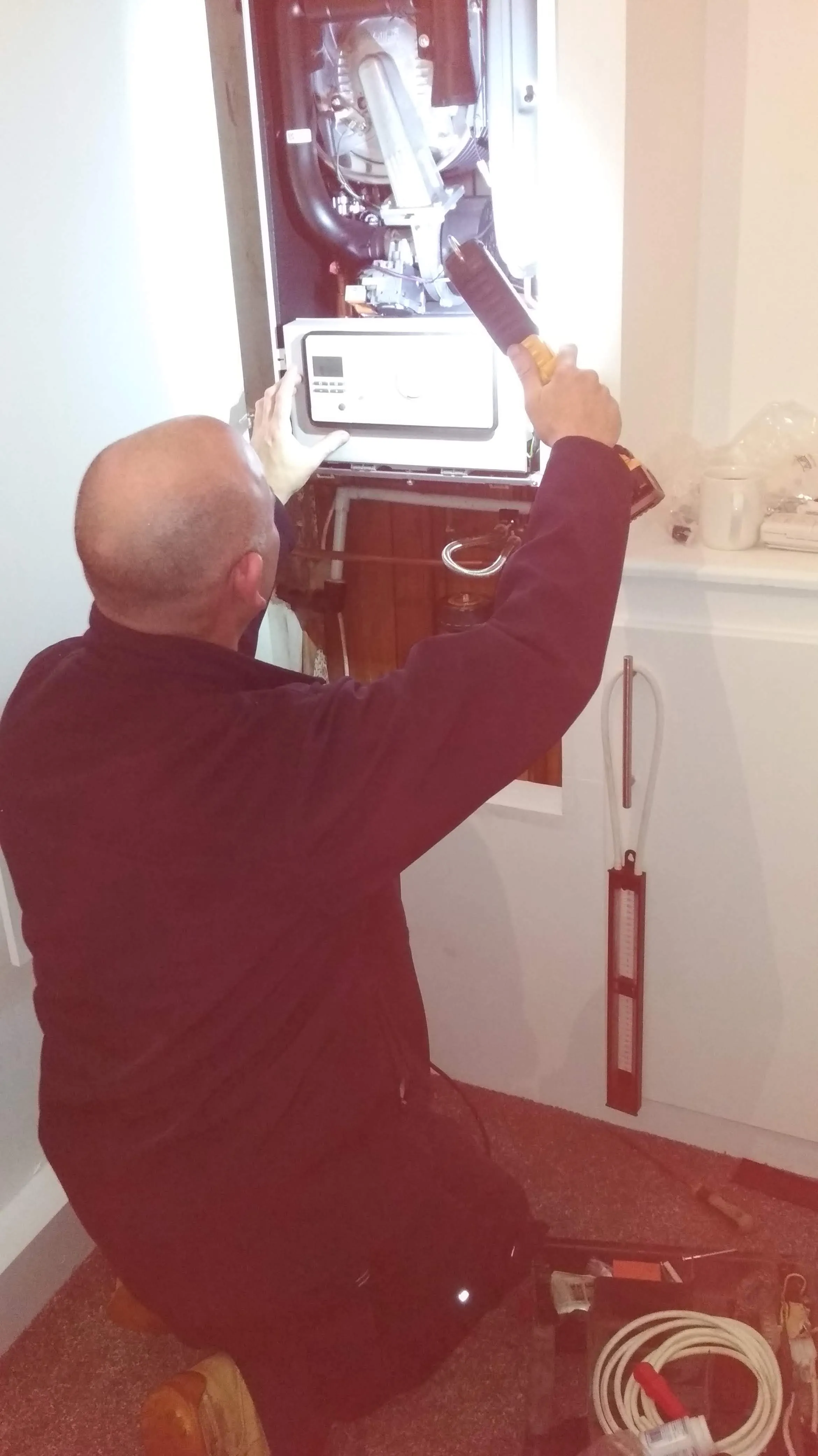 A plumber performing a boiler service or repair.
