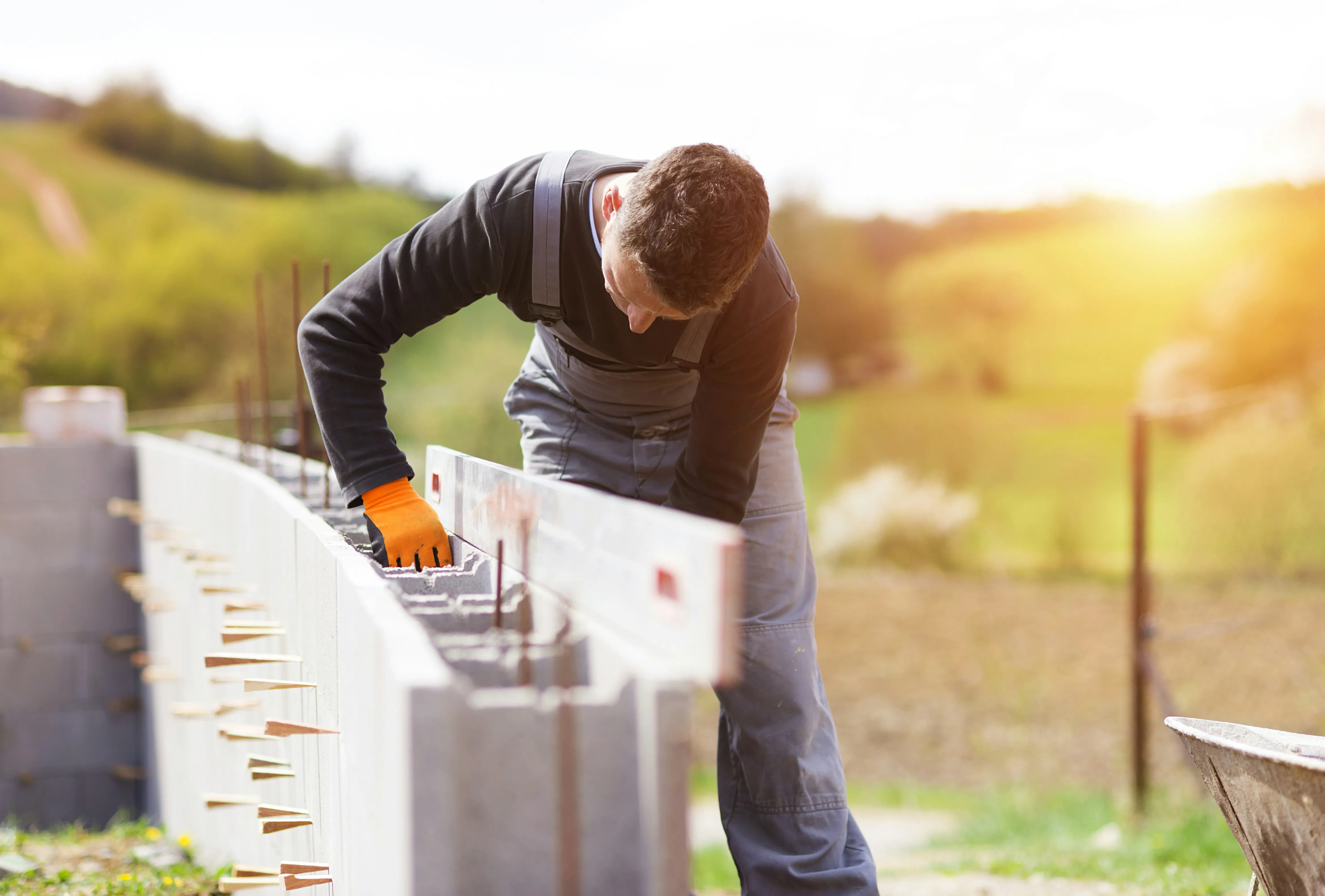 Construction worker using a spirit level to check a block wall