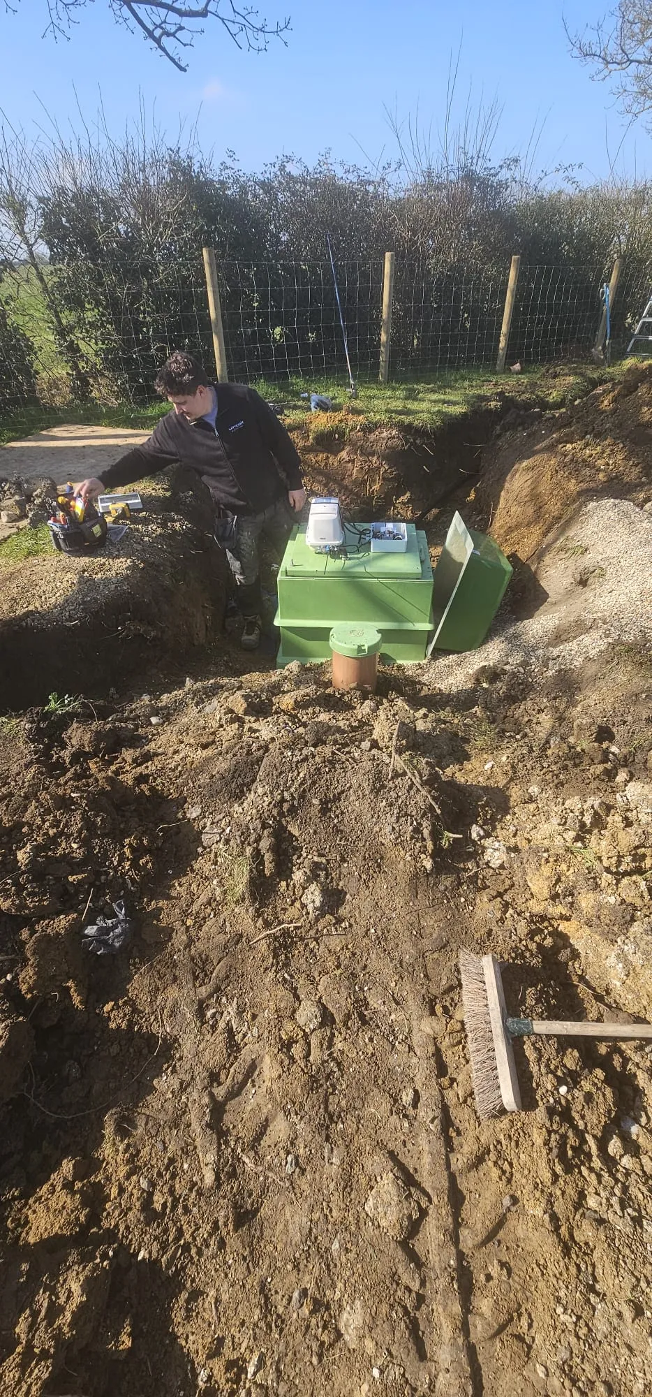 Eco Drain Solutions Ltd technician installing a new sewage treatment plant or septic tank on a rural property.