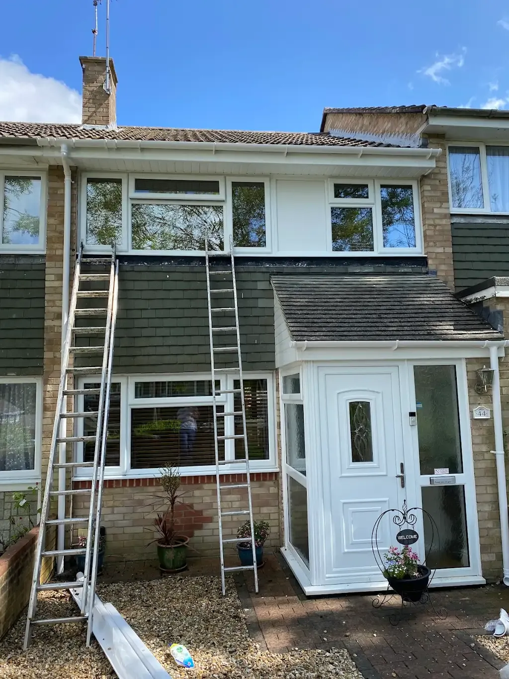 Exterior of a house with ladders during roofline or high-level renovation work in Southampton and The South Of England