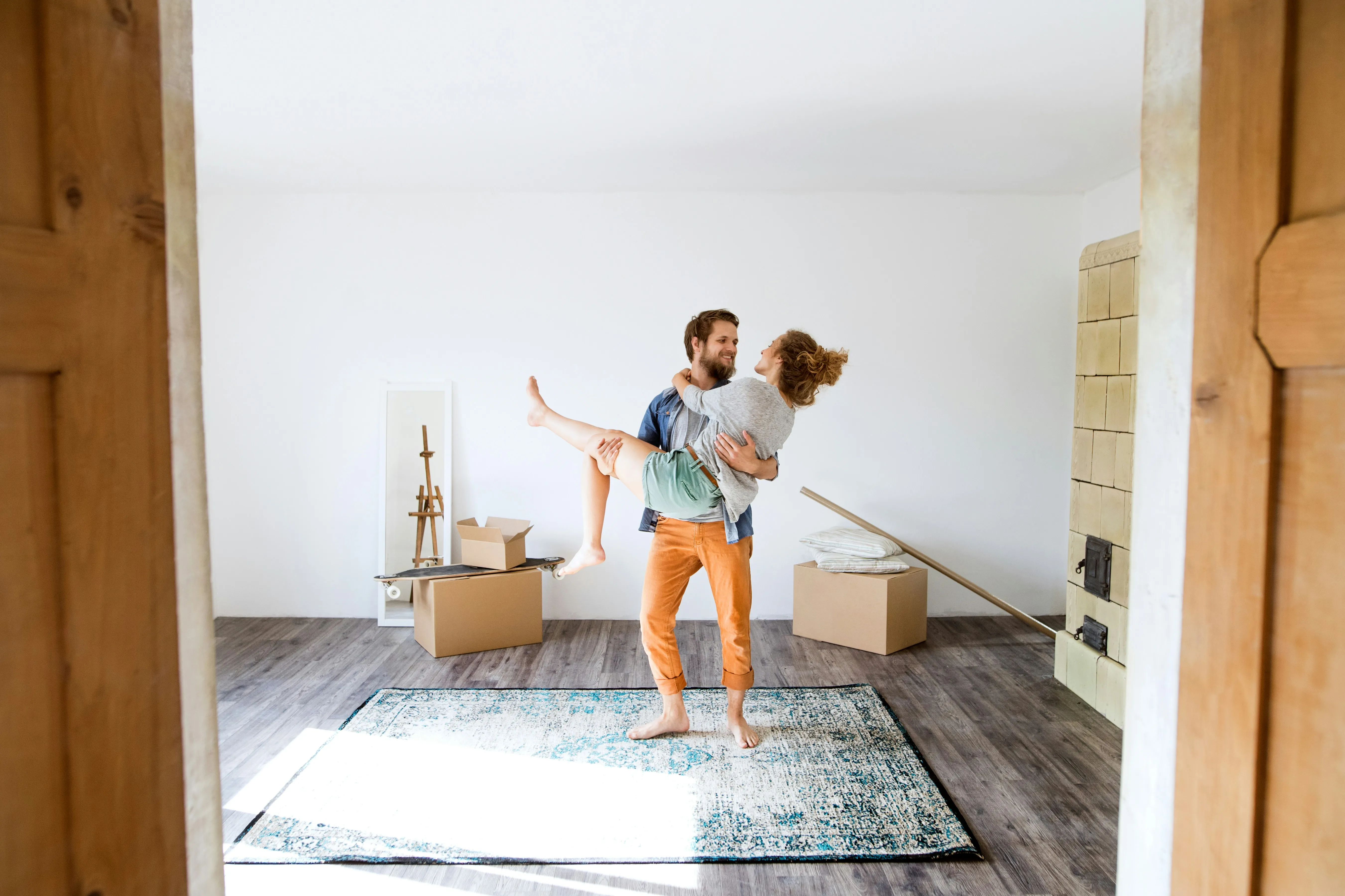 Happy couple celebrating a stress-free home move, surrounded by moving boxes in their new home.