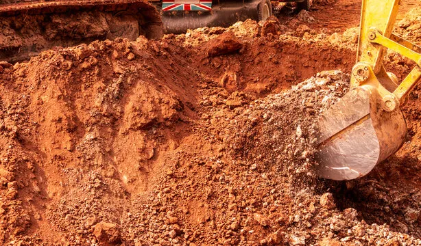 Close-up of an excavator bucket digging soil
