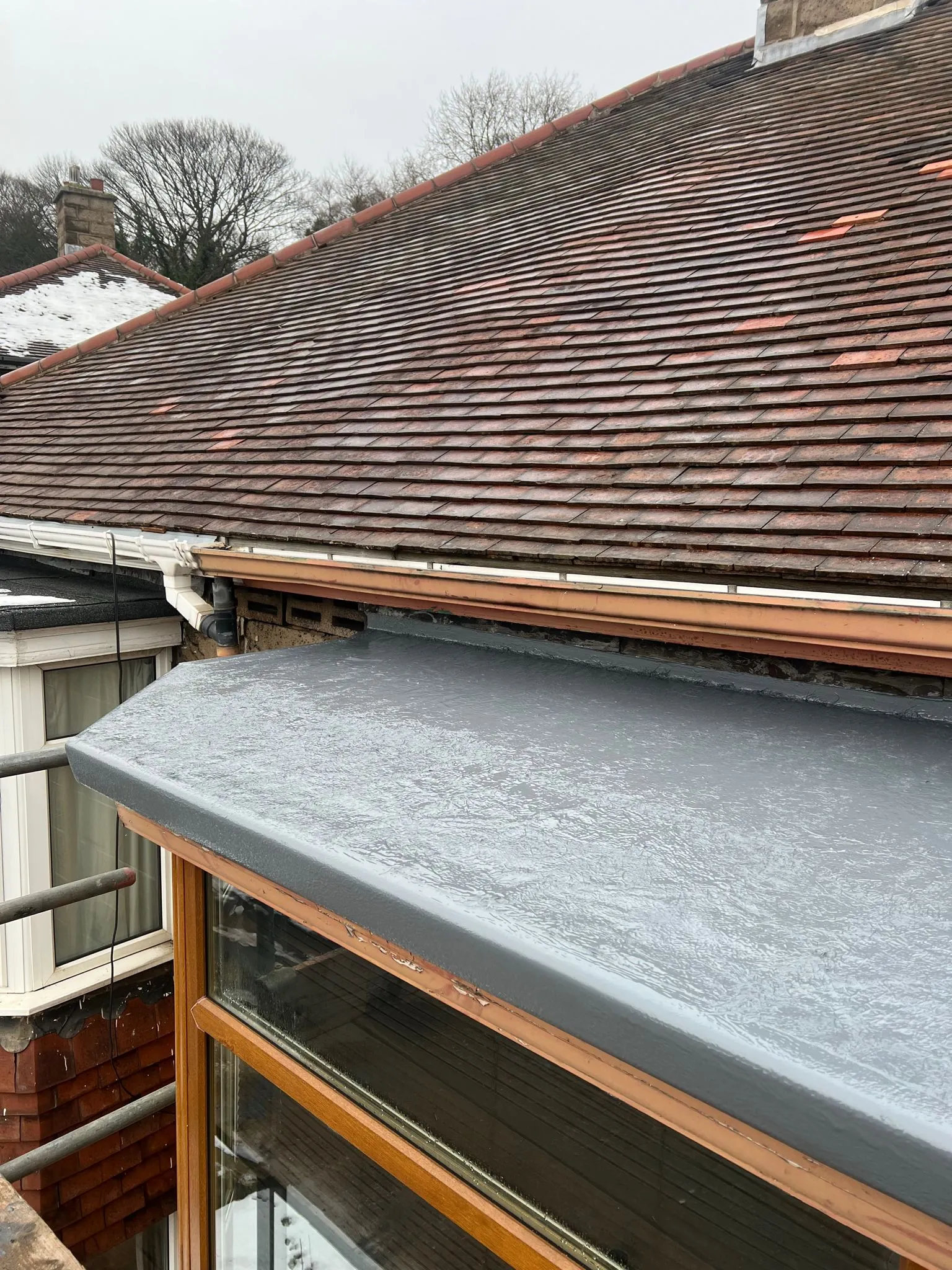 Newly installed flat roof on extension next to pitched tiled roof in Sheffield