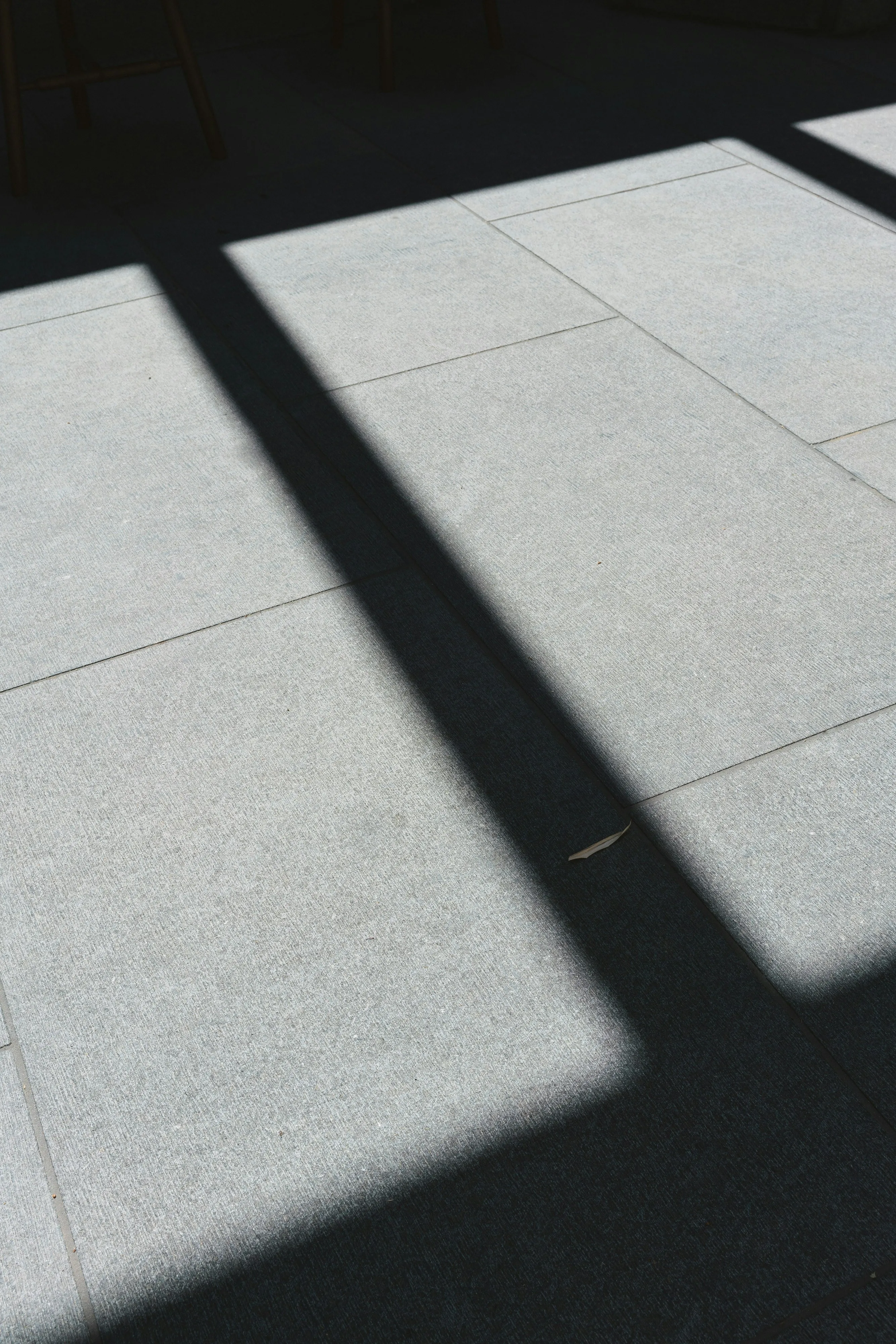 Close-up of grey patio paving slabs with sunlight and shadows