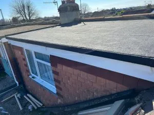 Newly installed flat roof on a house extension with white uPVC fascias and a window.