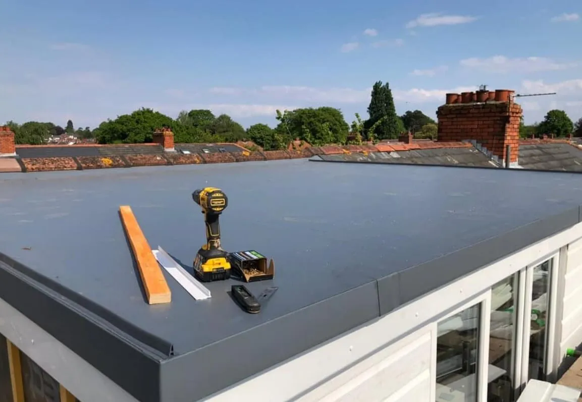 Newly installed grey flat roof with roofing tools