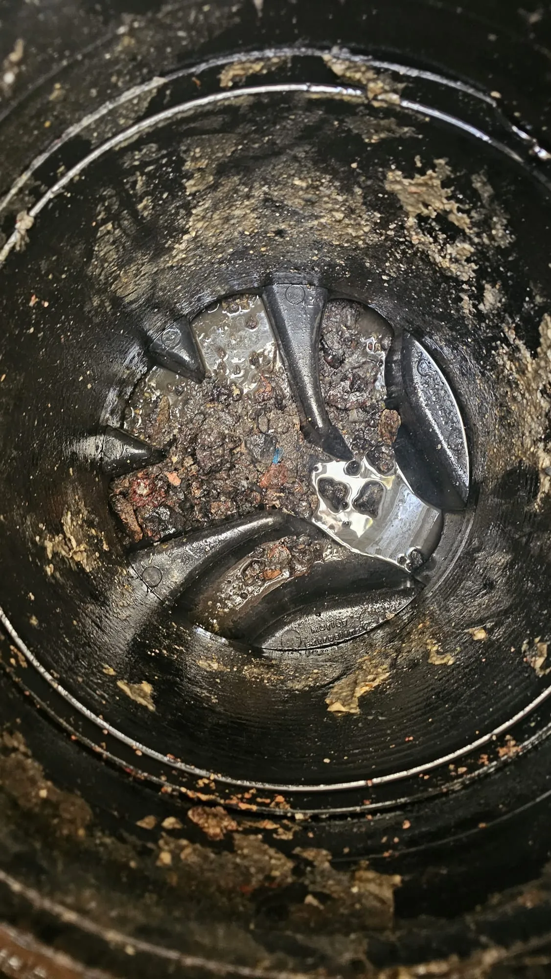 A close-up picture of a blocked outdoor drain with debris