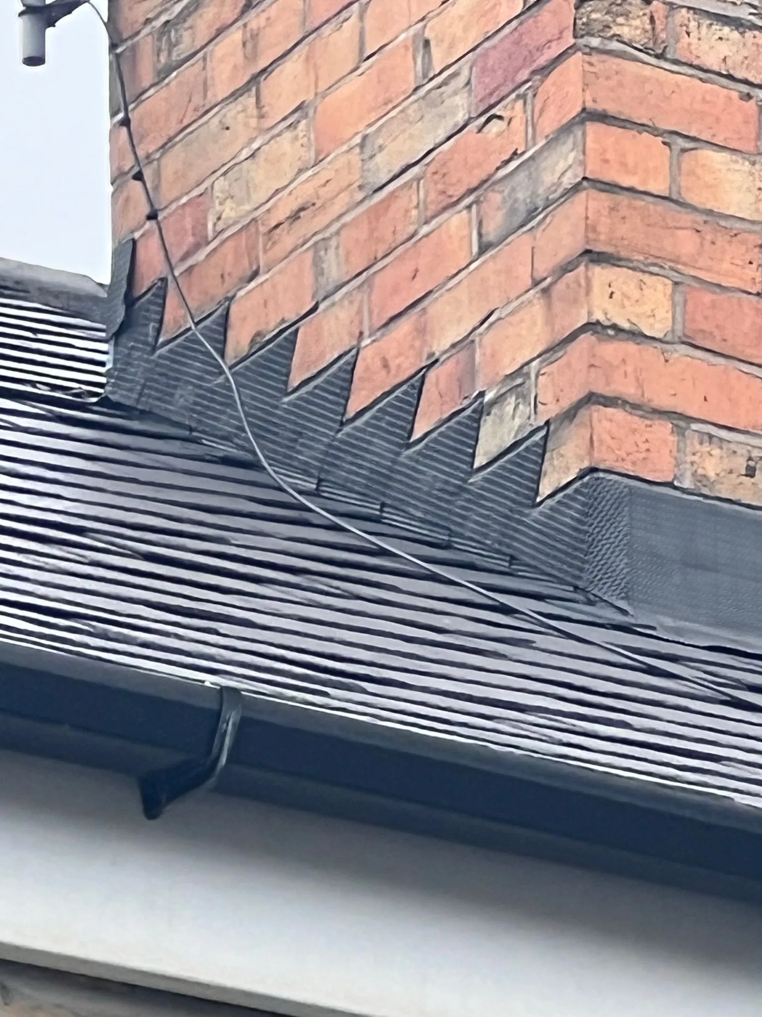 Detail of chimney base flashing and roof tiles on a Sheffield or Peak District home