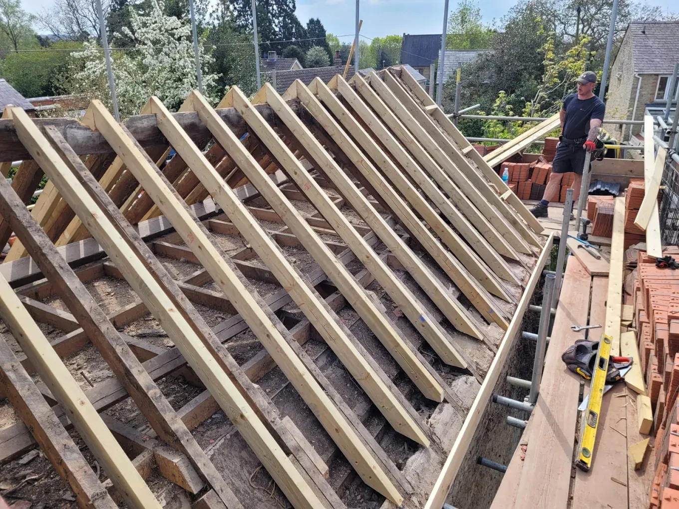 Roofer working on new pitched roof timber structure during installation or replacement