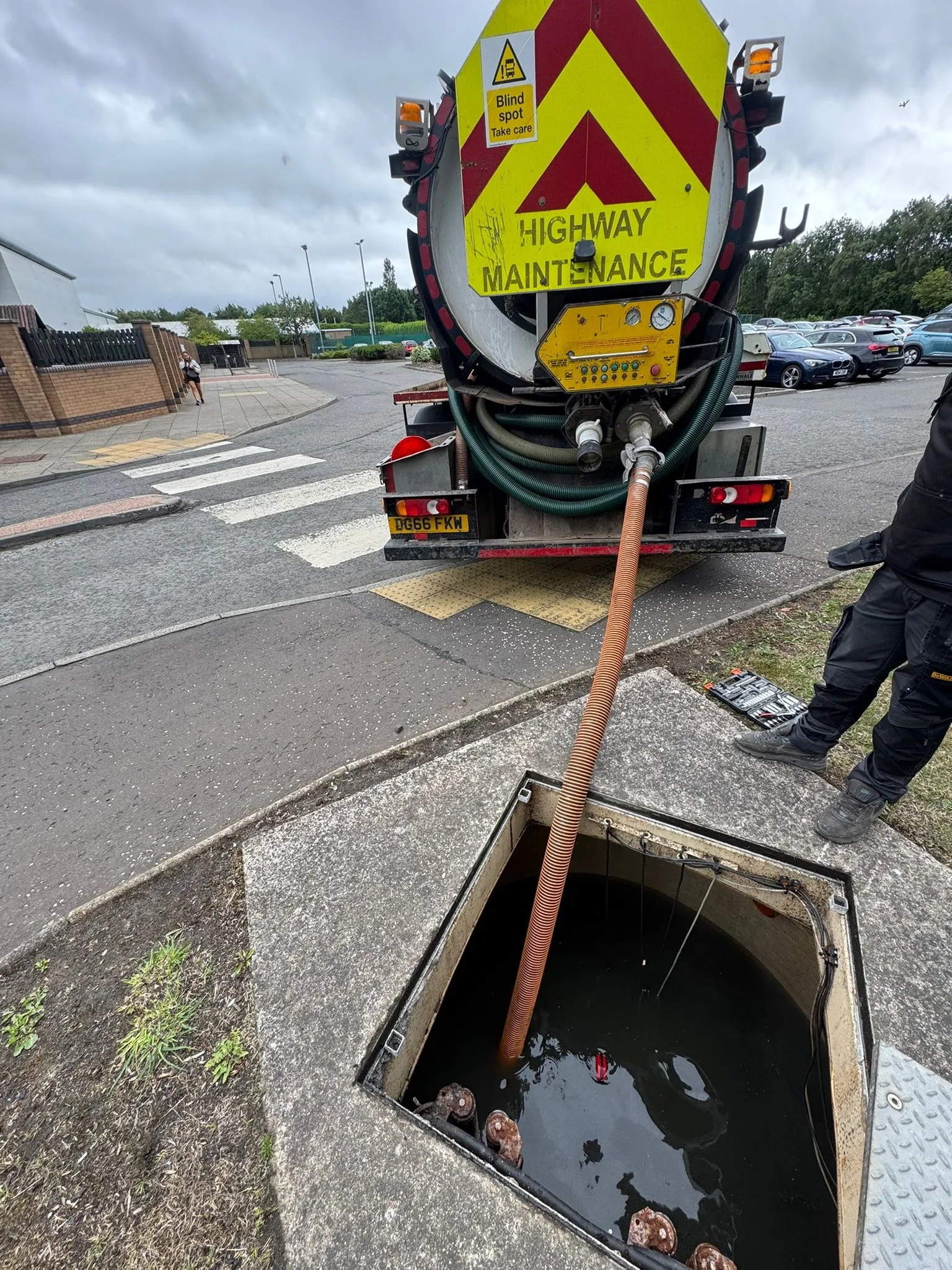 Drainage tanker truck with hose in a manhole