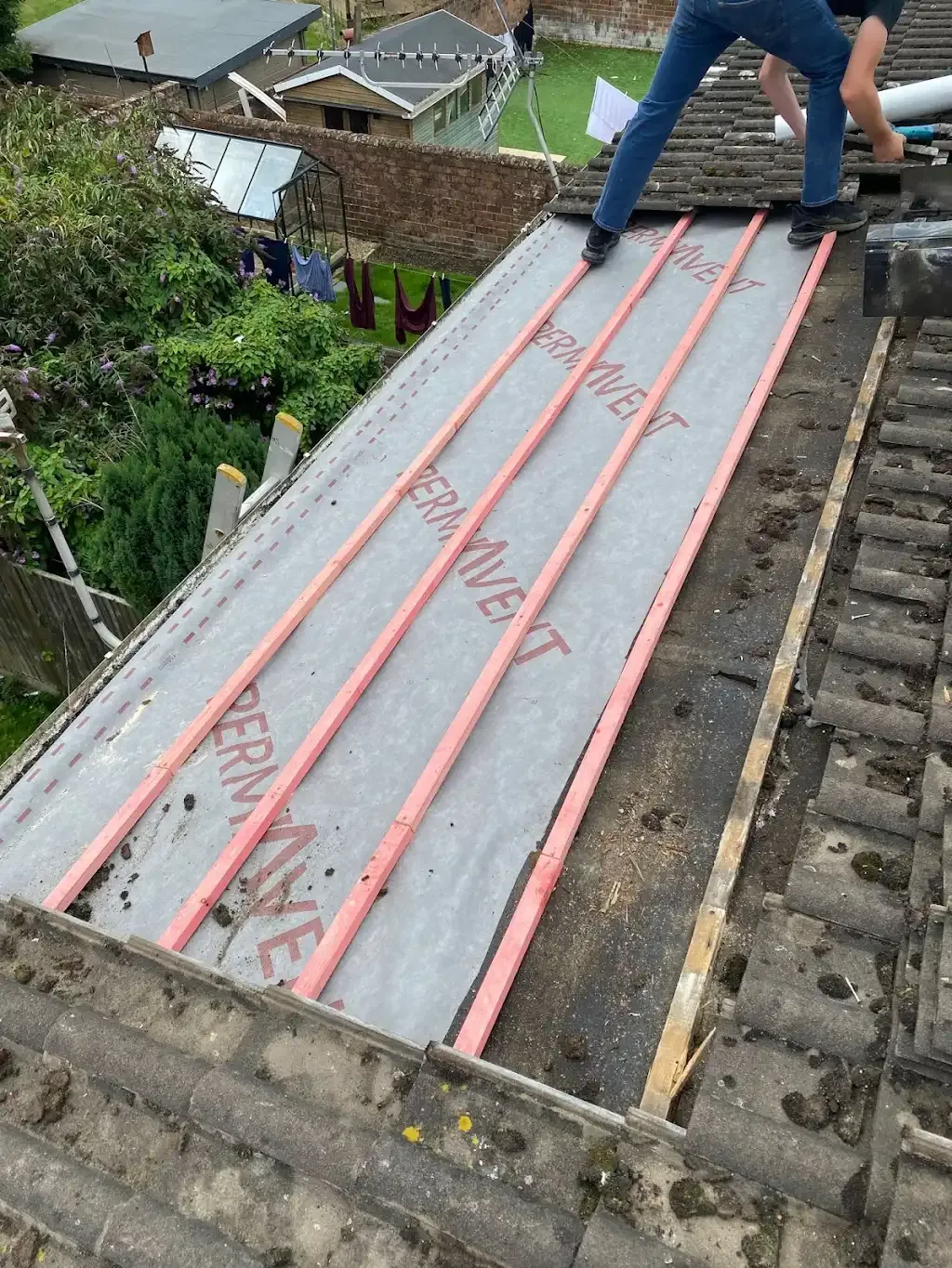 Installation of roof underlayment and battens on a pitched roof.
