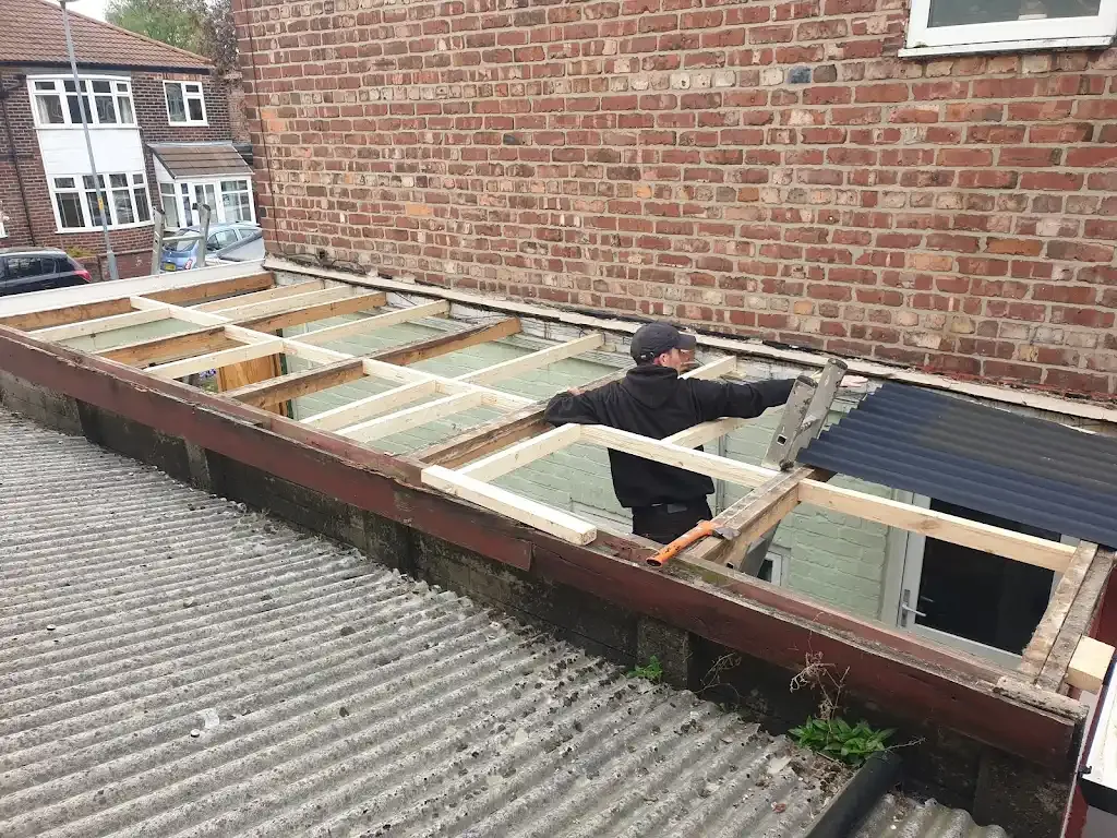A roofer installing wooden joists for a flat roof