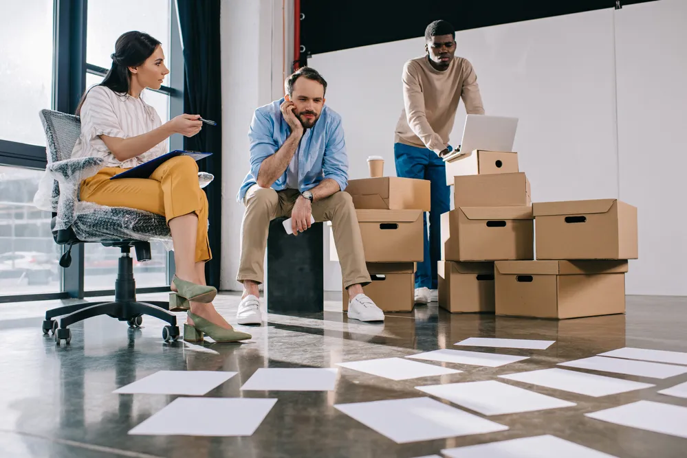 Expert team discussing office relocation with moving boxes for a seamless business move.
