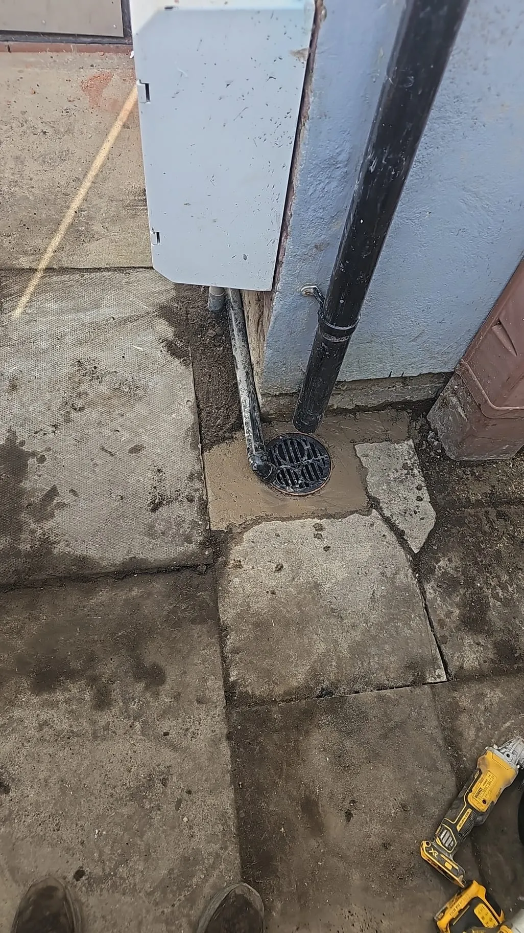 Newly installed or repaired gully drain at a residential property with fresh cement.