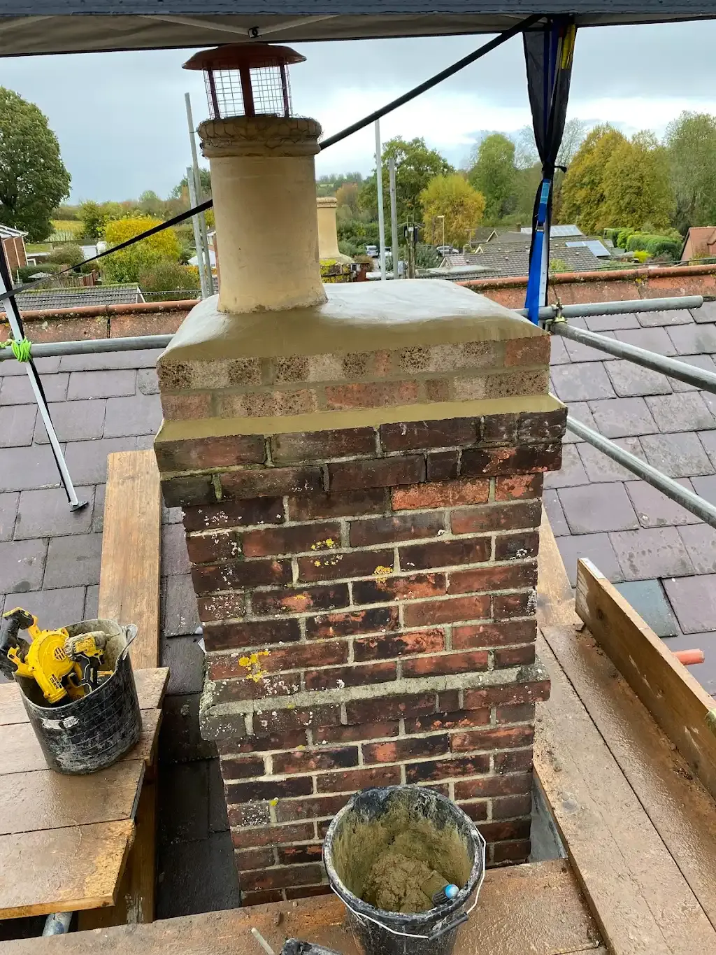 Chimney undergoing repair with new mortar on a tiled roof