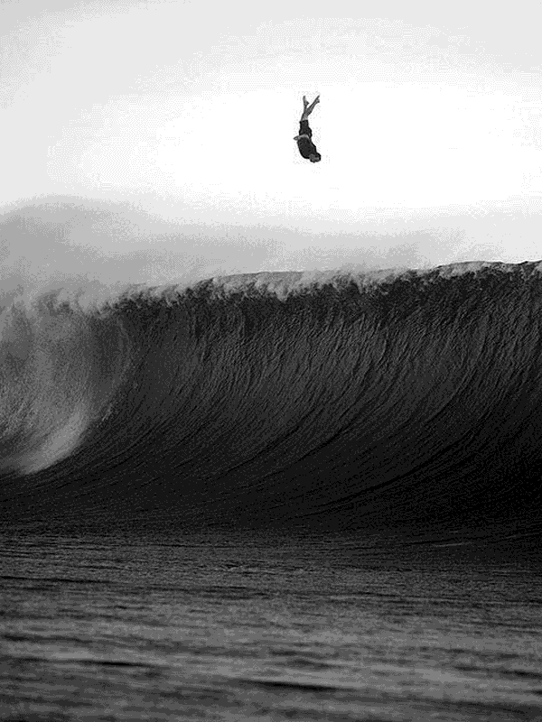Surfer mid-air above massive dark wave for Other e-reader wallpaper or screensaver featuring surfing and big-wave and more