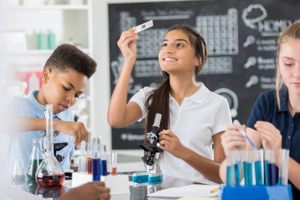 Middle school students in a science lab performing hands-on experiments as part of STEM education in the U.S. public education system.