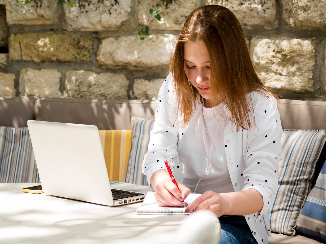 College student working on her career development plan with a laptop and notes.