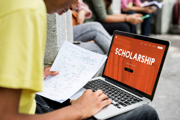 High school student searching for study abroad scholarships on a laptop.