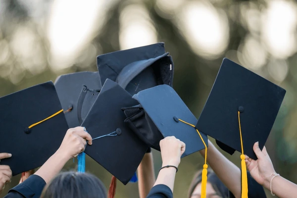 High school seniors in caps celebrating their graduation at a U.S. public school.