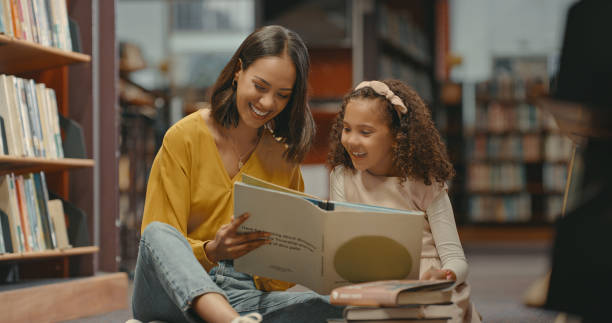 Parents and children exploring career planning by reading books about different professions at a library.