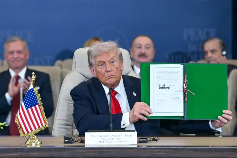 US President Donald Trump shows a signed document during a summit on Gaza in Sharm el-Sheikh on October 13, 2025