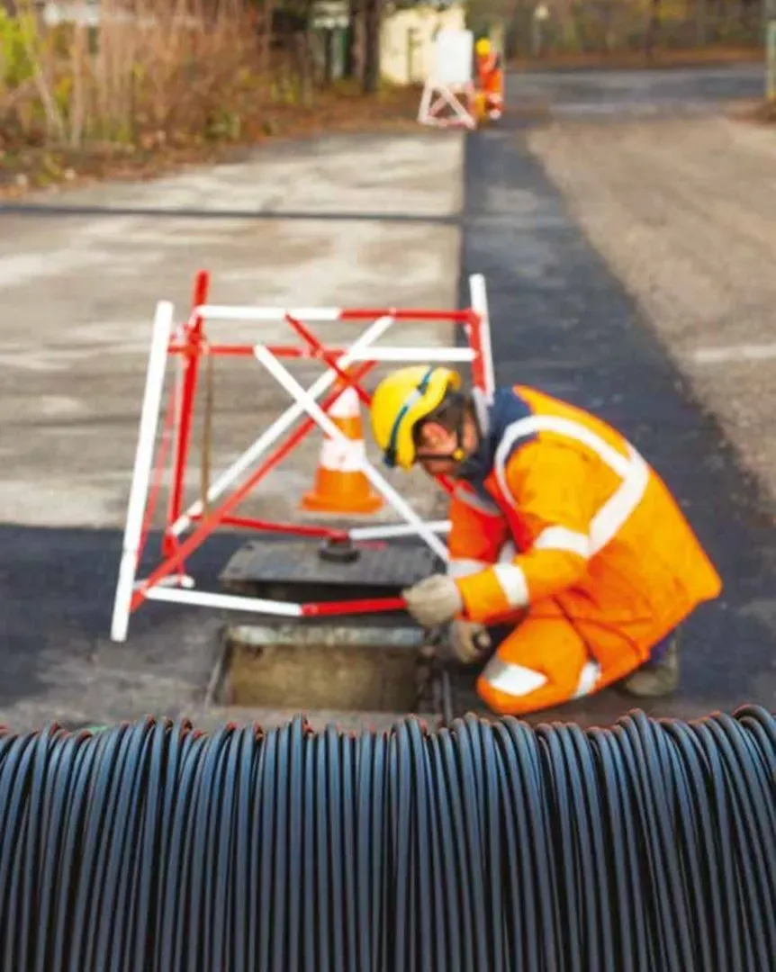 Un technicien procède au déploiement de la fibre optique dans les fourreaux souterrains. © Axione