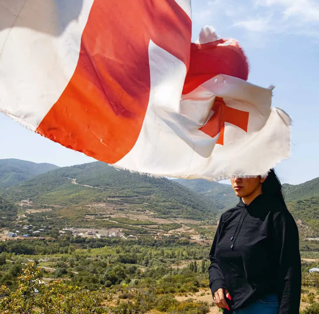 Une femme cachée par un drapeau géorgien. 