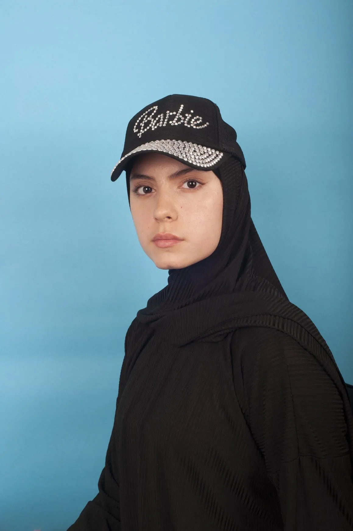 Une femme voilée avec une casquette Barbie. 