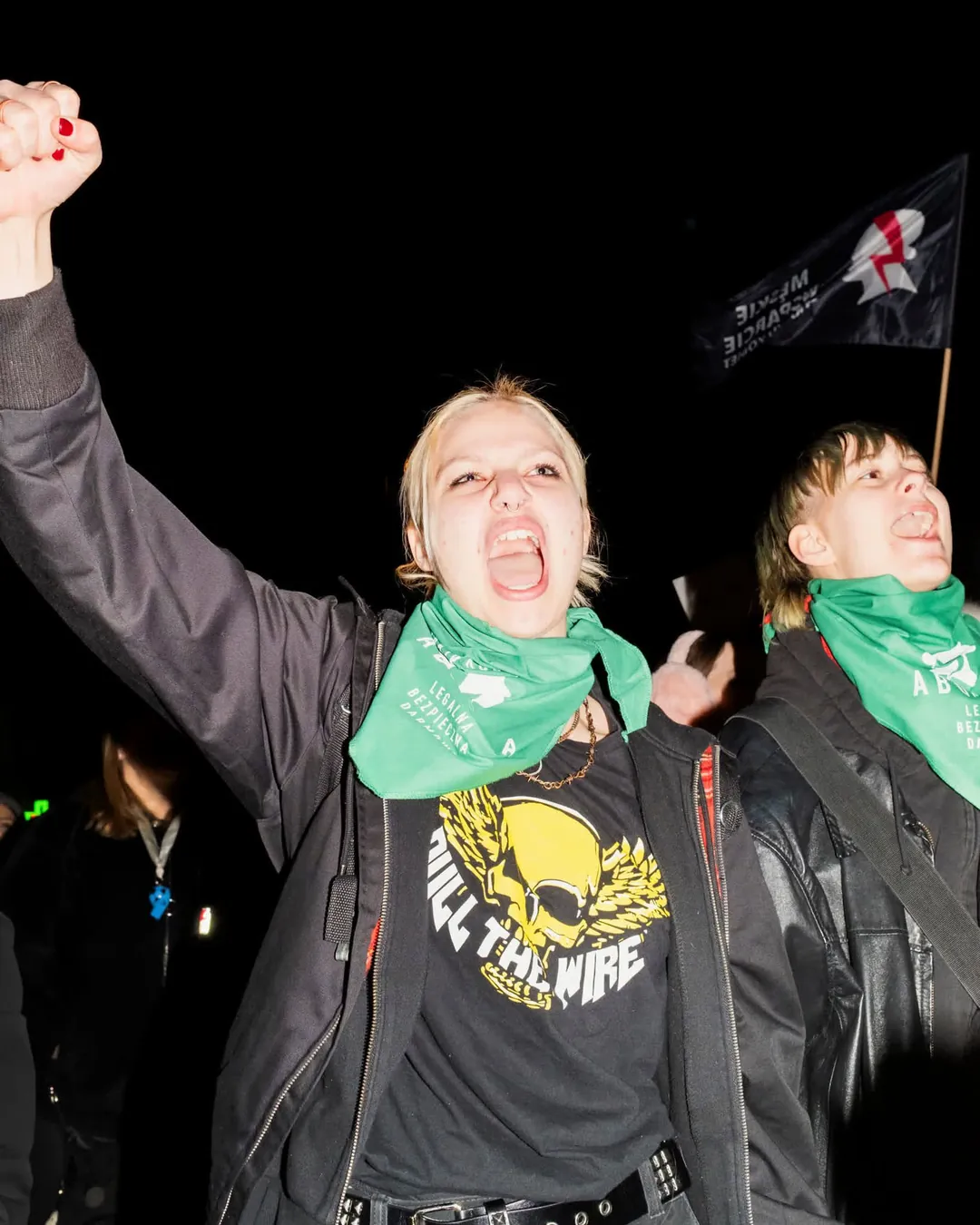 Une jeune femme brandit un point dans une manifestation. 
