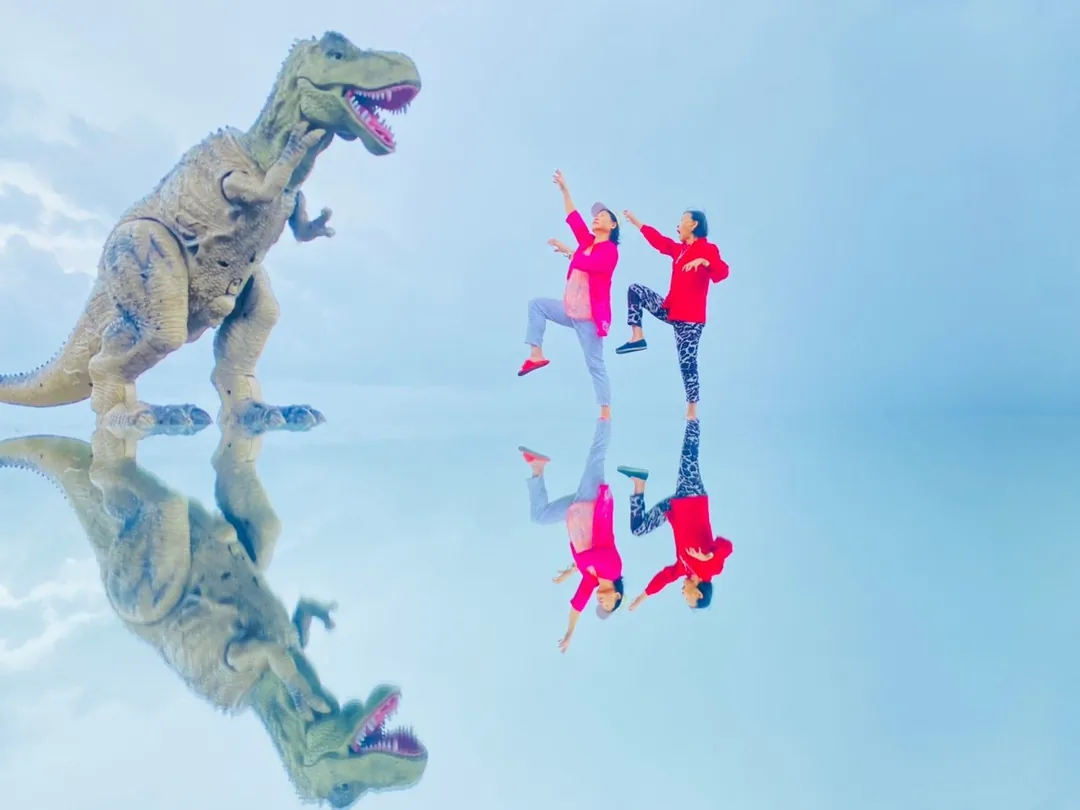 Deux femmes posent devant une photo de T Rex