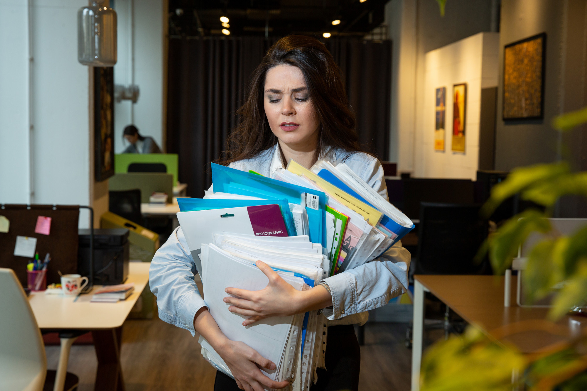 Professional carrying a stack of client files and documents