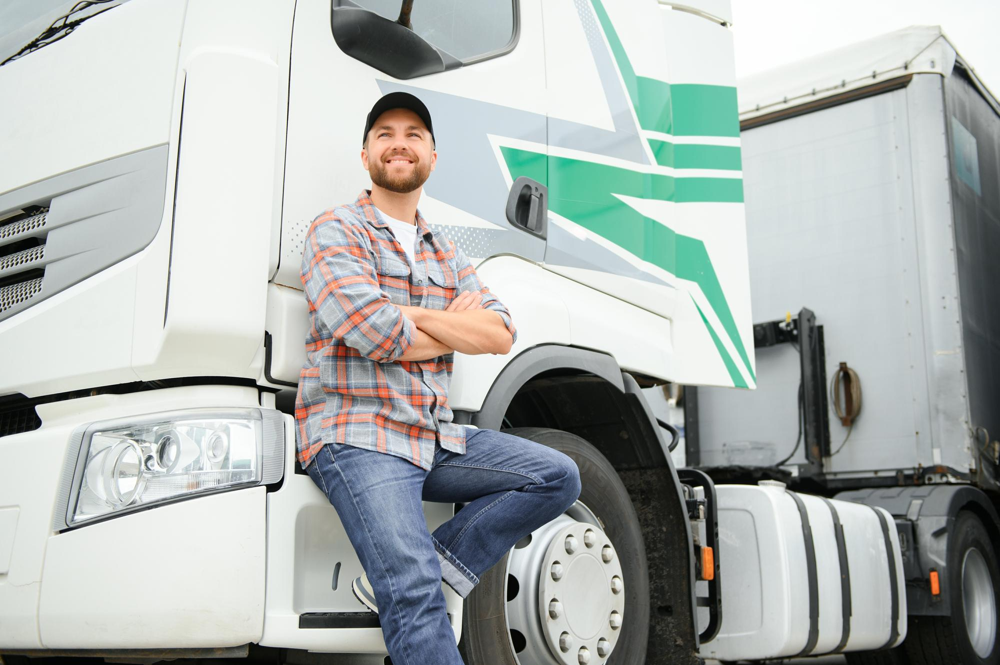 Truck driver standing confidently beside a truck