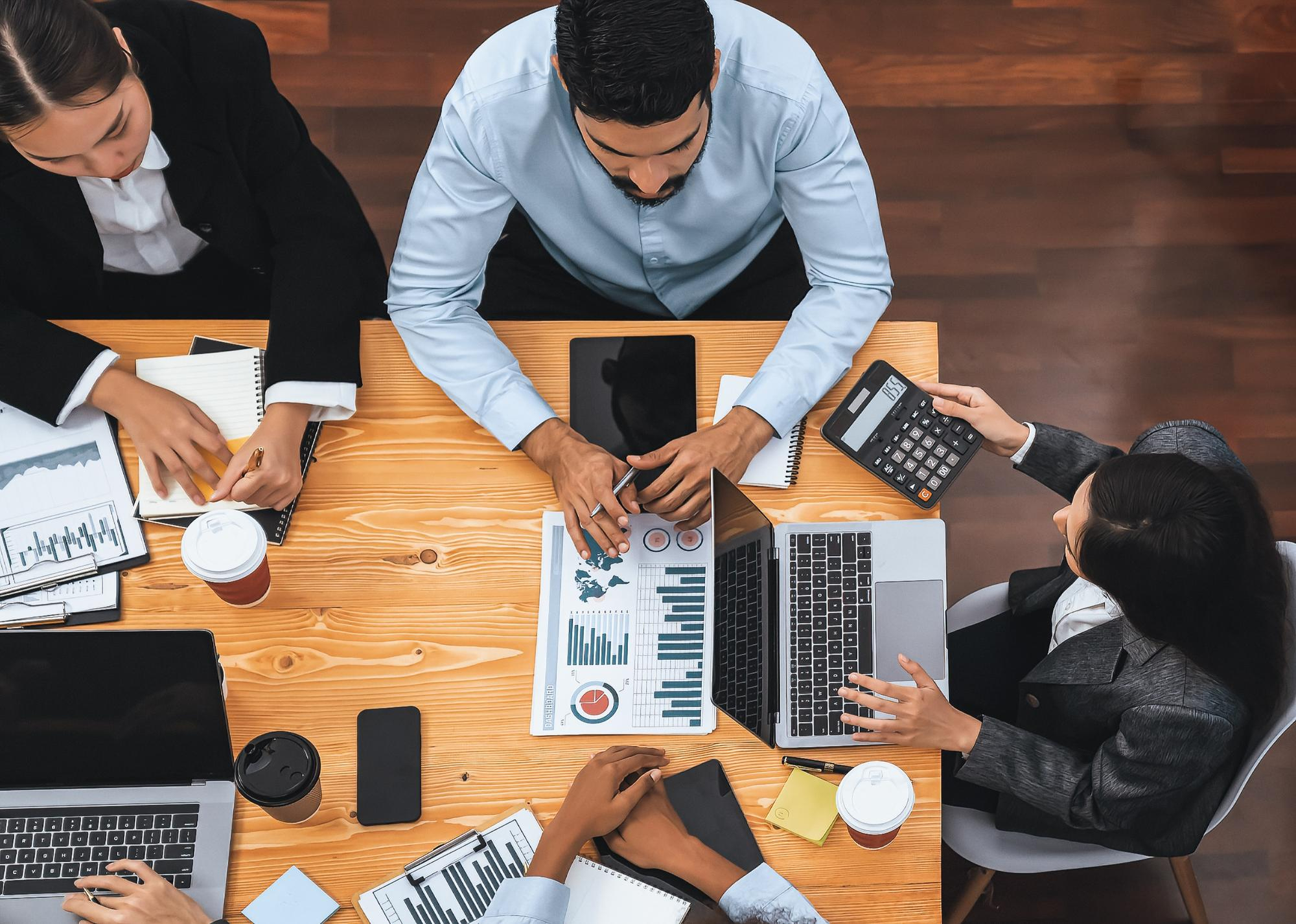 Business team reviewing reports and financial documents around a table