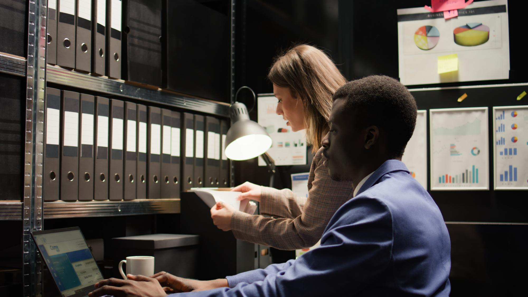 Two professionals reviewing client documents in an office