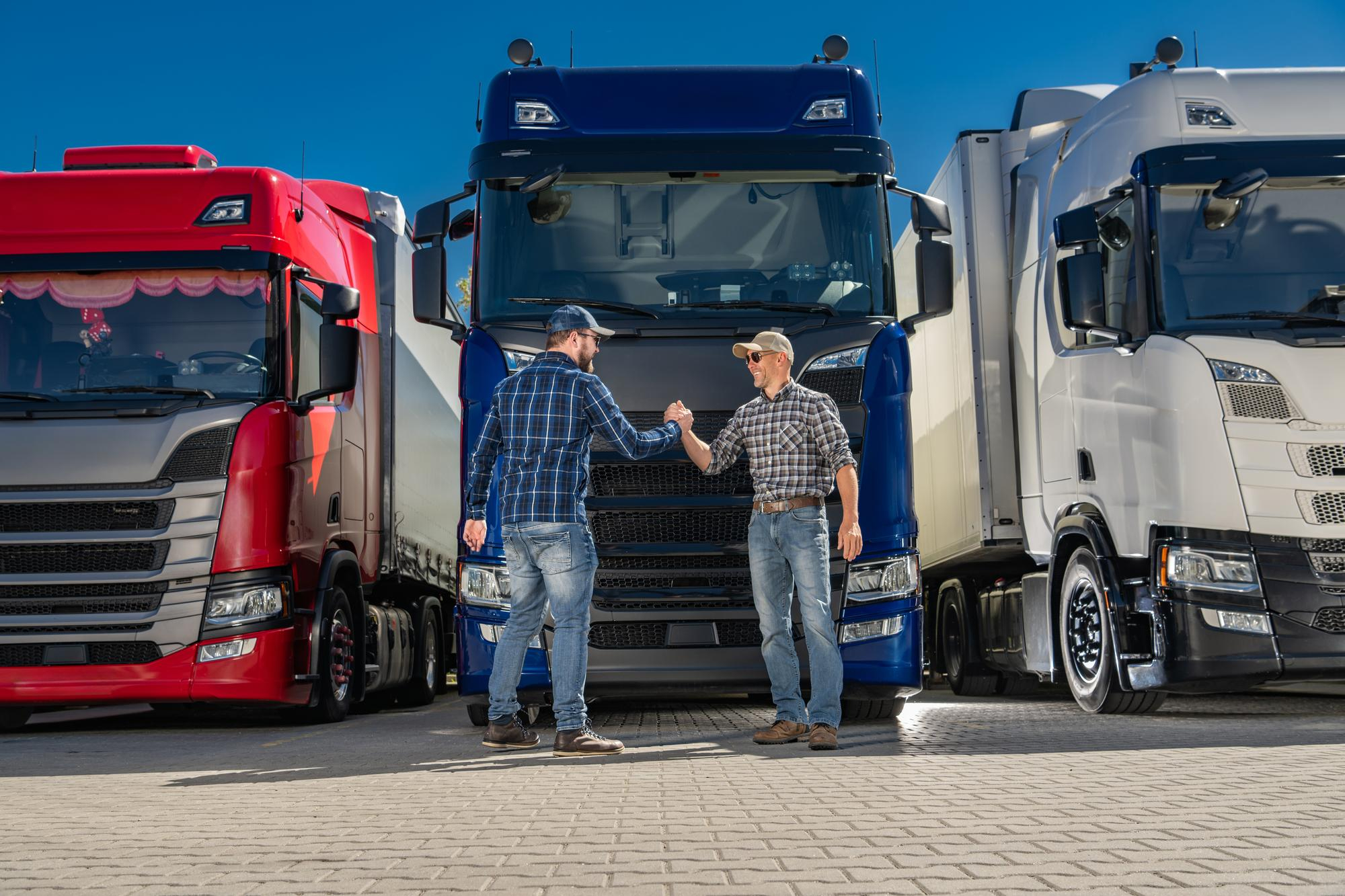 Truck operators standing in front of a blue semi truck