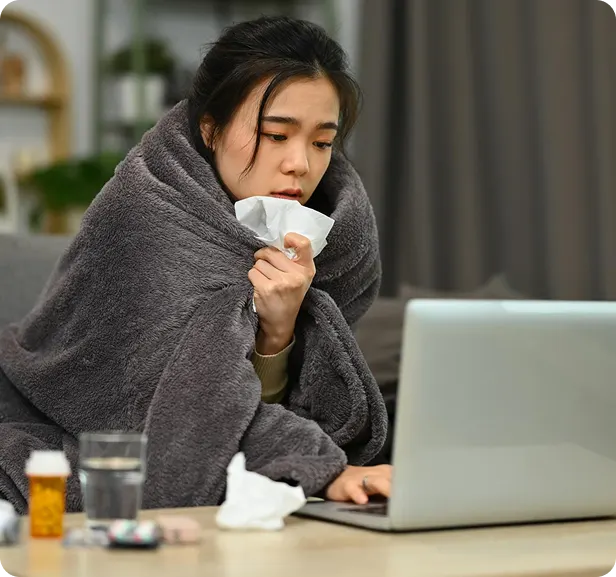 Person with blanket using laptop